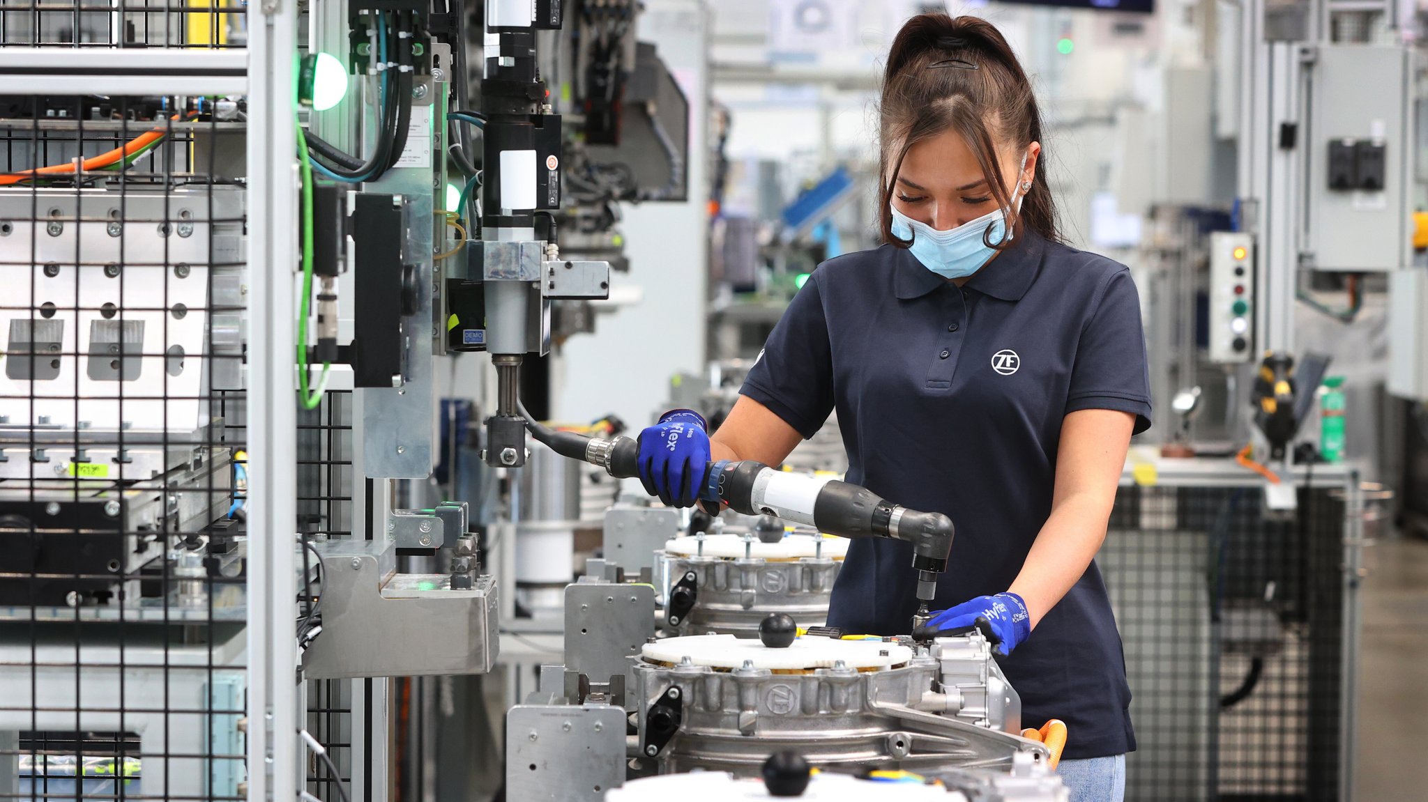 Emilia Schuhmacher, Maschinenbedienerin, verschraubt in der Montagehalle für Elektromobilität der ZF Friedrichshafen AG, Stator und Phasenkabel an einem Elektromotor. | Bild: picture alliance/dpa | Karl-Josef Hildenbrand Emilia Schuhmacher, Maschinenbedienerin, verschraubt in der Montagehalle für Elektromobilität der ZF Friedrichshafen AG, Stator und Phasenkabel an einem Elektromotor.