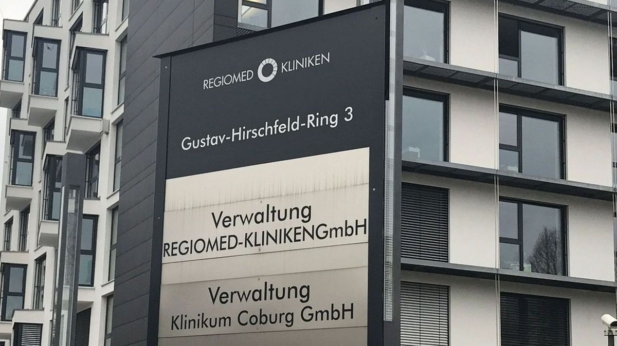 Auf einem Schild steht "Gustav-Hirschfeld-Ring 3 / Regiomed Kliniken / Verwaltung"