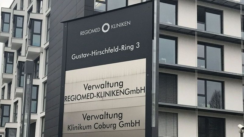 Auf einem Schild steht "Gustav-Hirschfeld-Ring 3 / Regiomed Kliniken / Verwaltung"