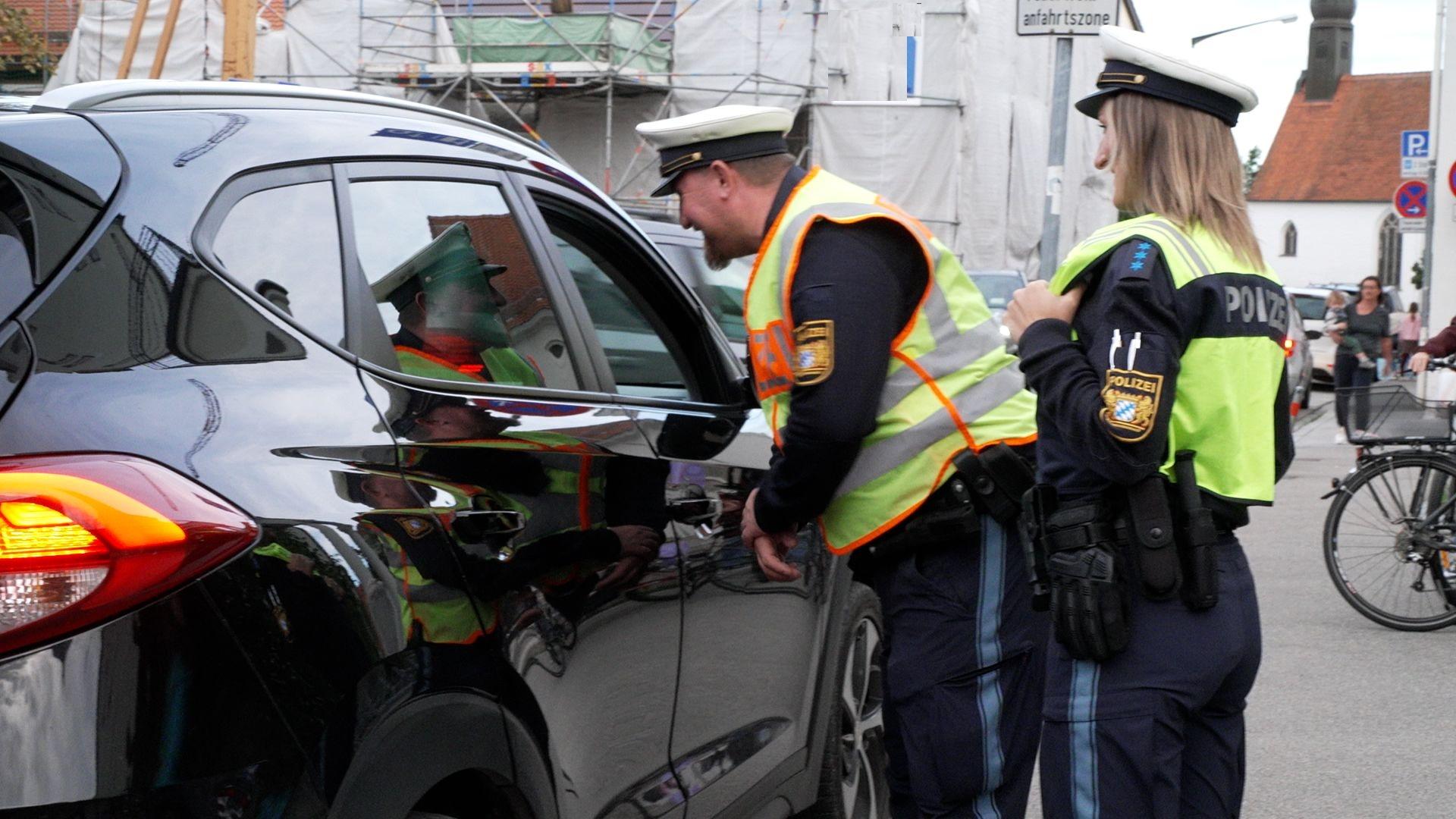 Polizeibeamte kontrollieren, ob die Kinder richtig angegurtet sind.