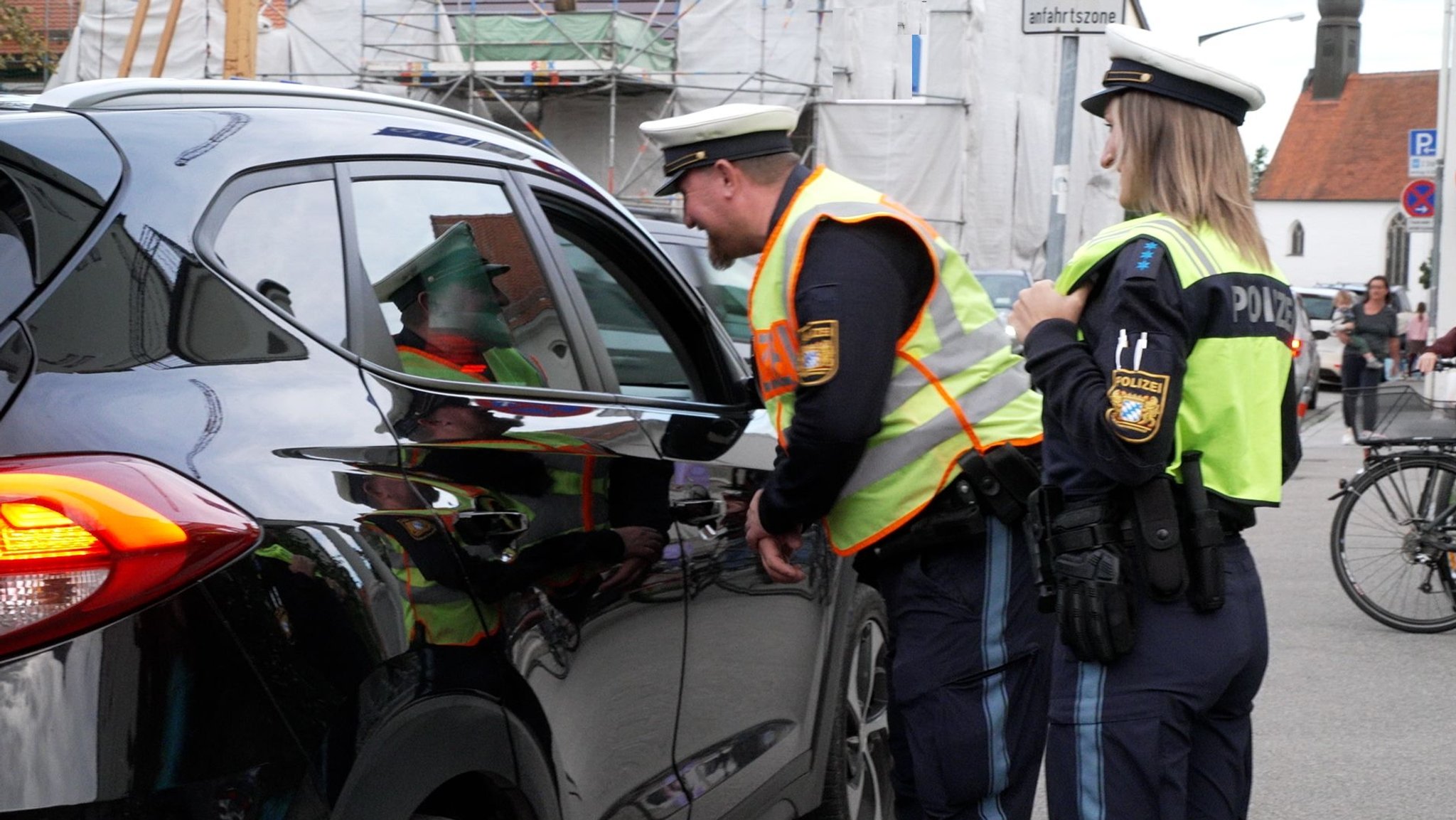 Polizeibeamte kontrollieren, ob die Kinder richtig angegurtet sind.