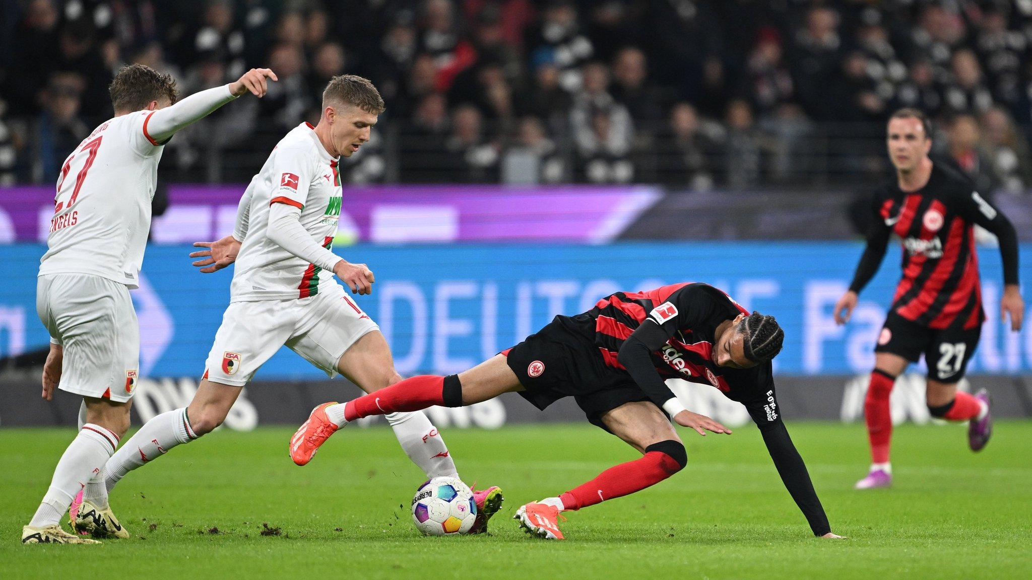 19.04.2024, Hessen, Frankfurt/M.: Fußball: Bundesliga, Eintracht Frankfurt - FC Augsburg, 30. Spieltag, Deutsche Bank Park. Frankfurts Hugo Ekitiké (2.v.r.) kämpft mit Augsburgs Kristijan Jakic (M) und Augsburgs Arne Engels (l) um den Ball. WICHTIGER HINWEIS: Gemäß den Vorgaben der DFL Deutsche Fußball Liga bzw. des DFB Deutscher Fußball-Bund ist es untersagt, in dem Stadion und/oder vom Spiel angefertigte Fotoaufnahmen in Form von Sequenzbildern und/oder videoähnlichen Fotostrecken zu verwerten bzw. verwerten zu lassen. Foto: Arne Dedert/dpa +++ dpa-Bildfunk +++