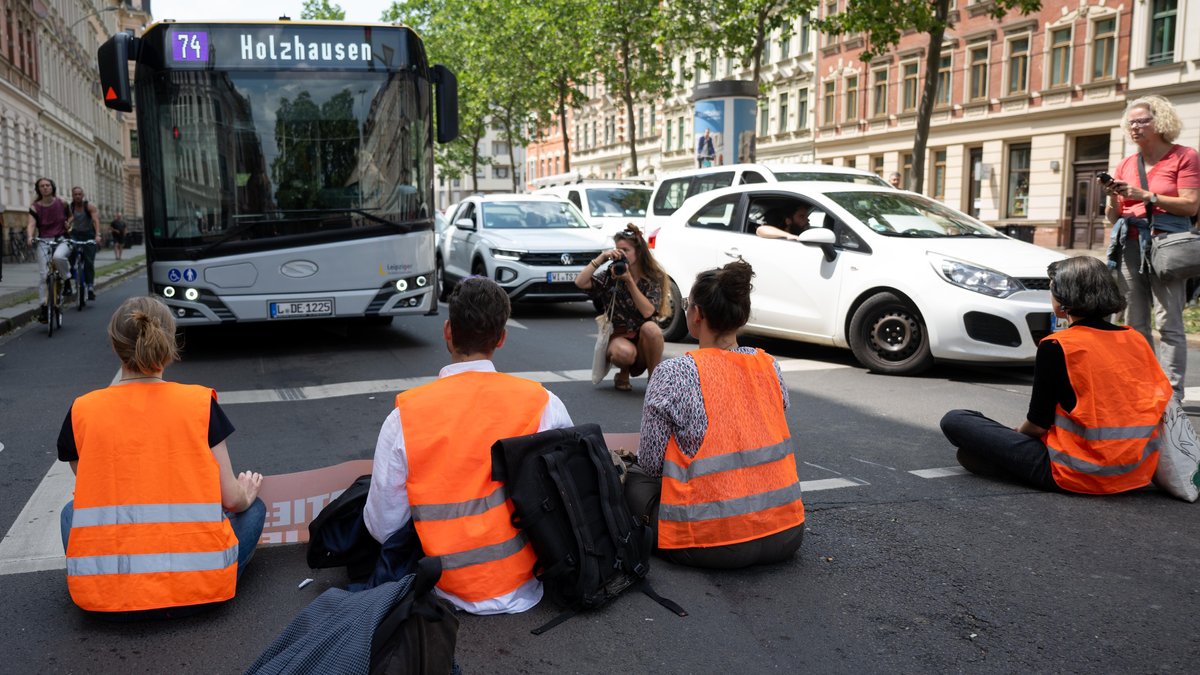 Klimaaktivisten der Gruppe "Letzte Generation" blockieren eine Straße.