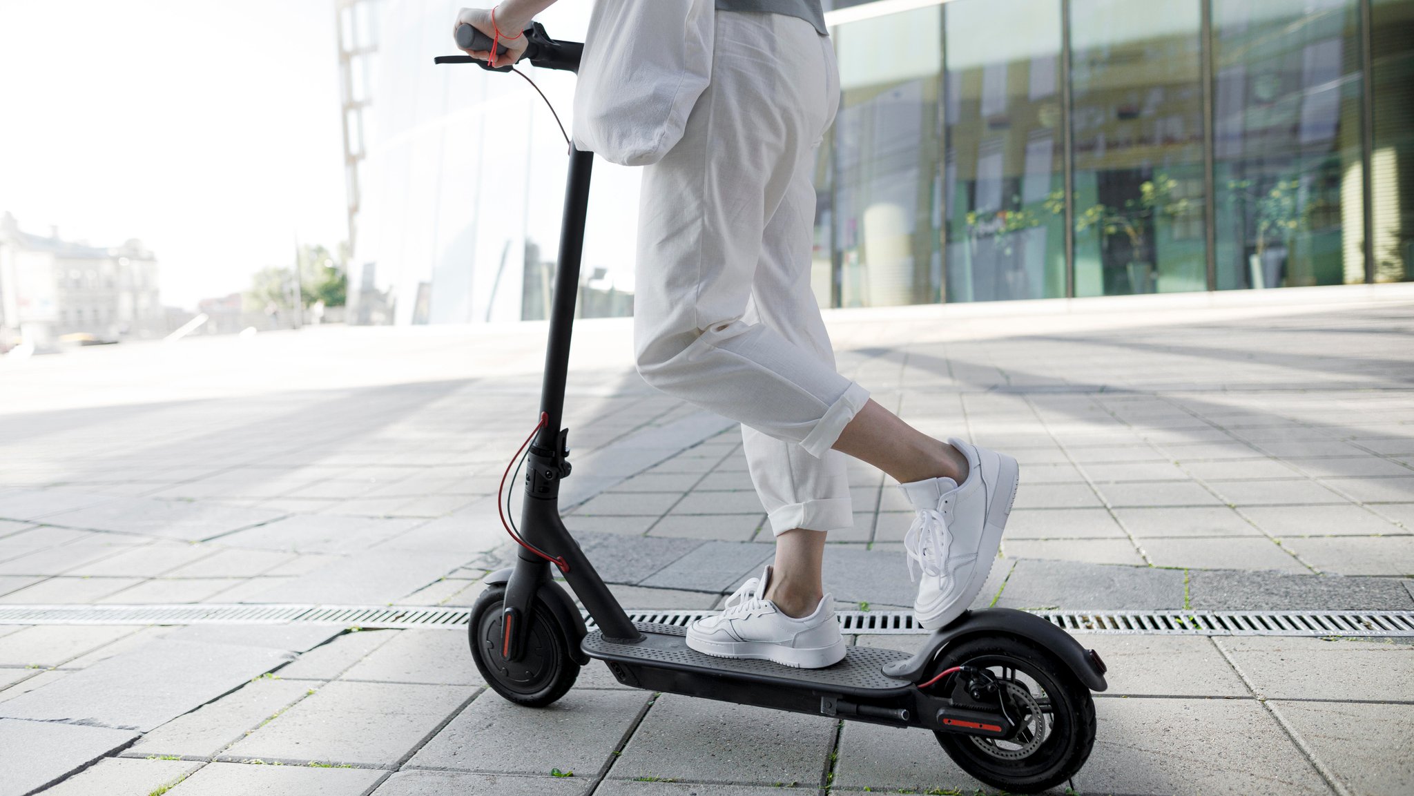 Junge Frau fährt auf einem E-Scooter.