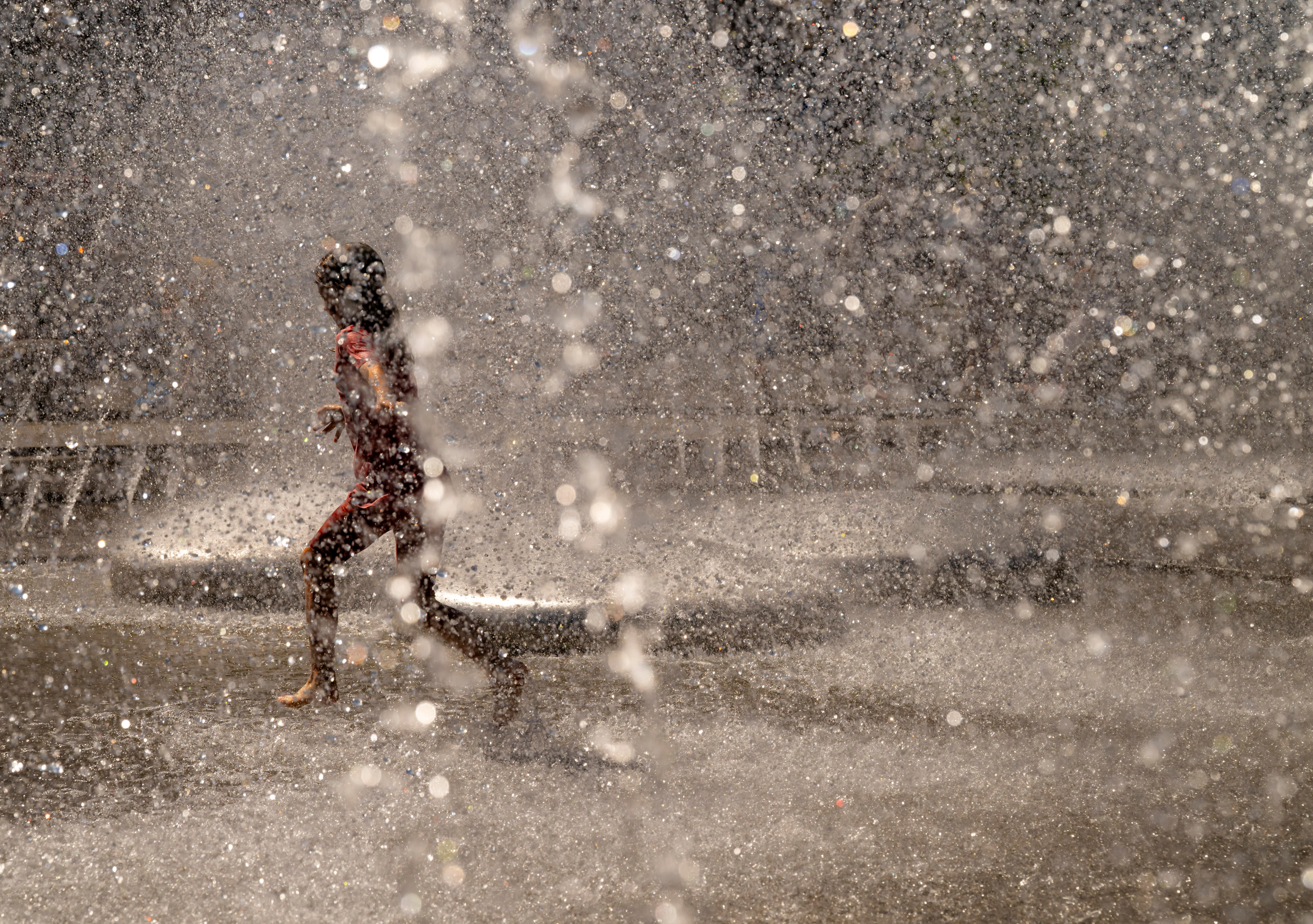 Ein Kind spielt in einem Brunnen am Stachus in der Münchner Innenstadt im Wasser. | Bild:picture alliance/dpa | Peter Kneffel