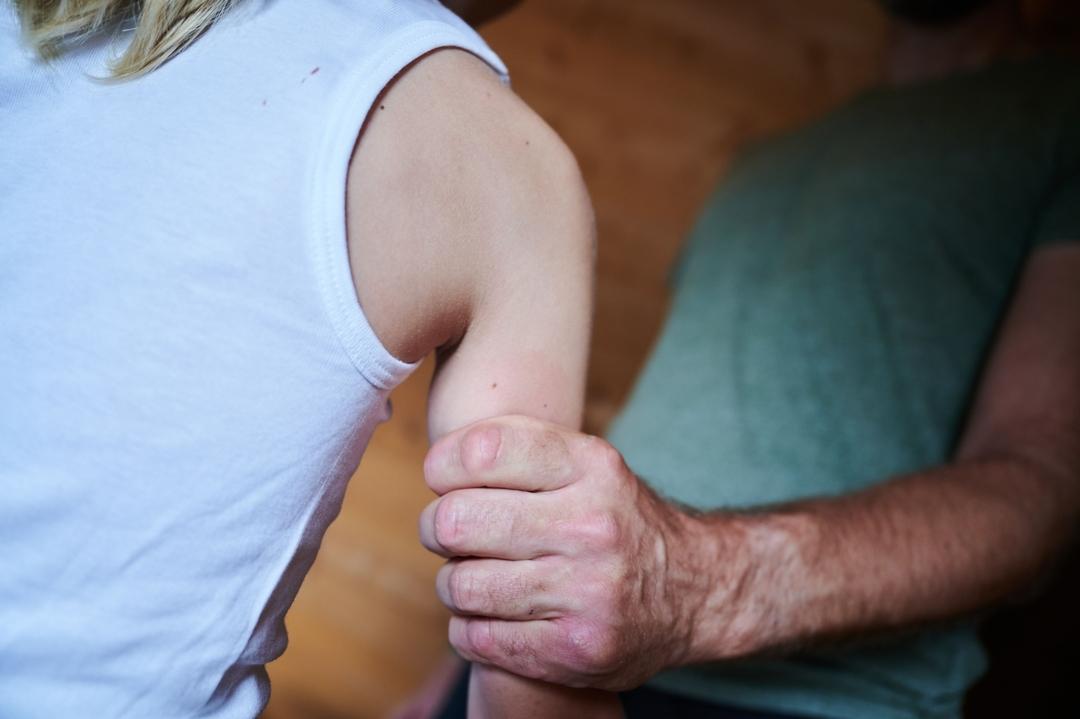  Ein Mann hält ein Kind fest am Arm (gestellte Szene)