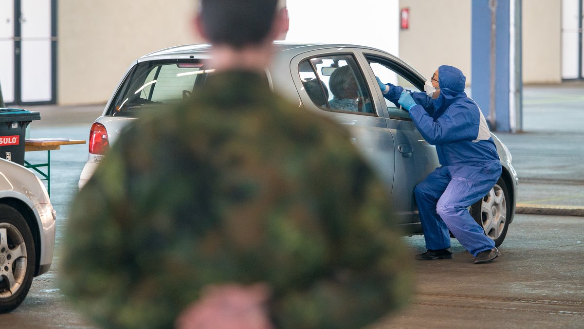 Ein Arzt nimmt bei der von der Bundeswehr organisierten Drive-in-Teststation in Saarbrücken einen Abstrich.