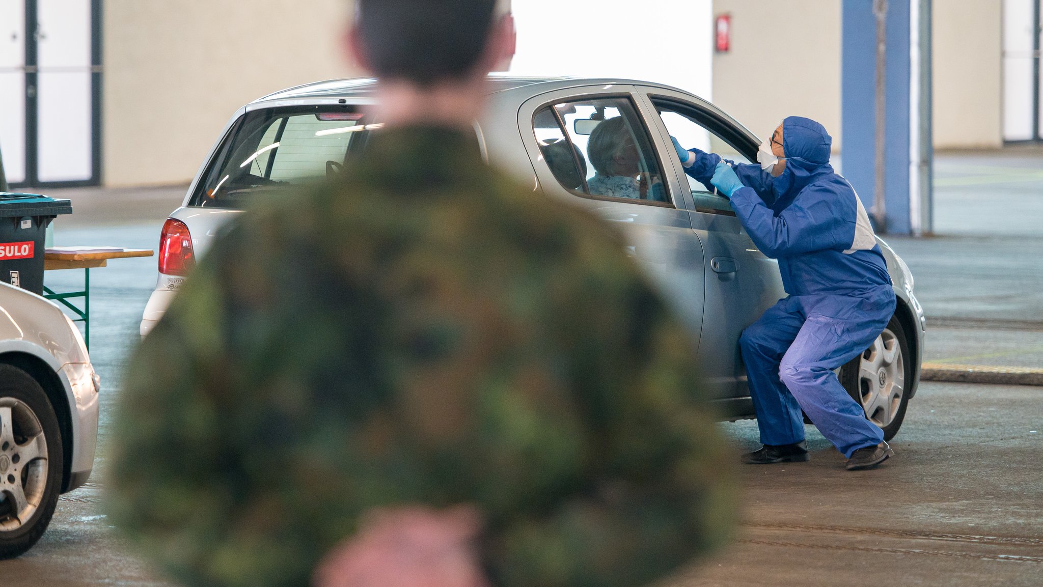 Ein Arzt nimmt bei der von der Bundeswehr organisierten Drive-in-Teststation in Saarbrücken einen Abstrich.