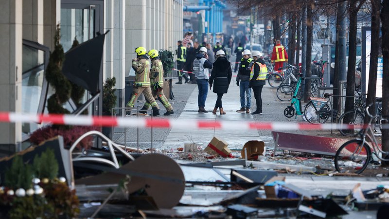 Rettungskräfte arbeiten auf der Straße vor dem Hotel, nachdem der "Aquadom" in Berlin-Mitte geplatzt war.