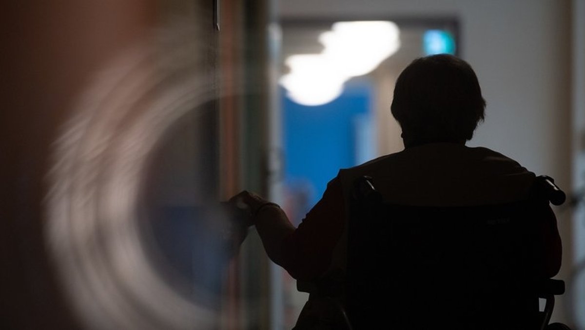 Eine Frau sitzt in einem Alten- und Pflegeheim in einem Rollstuhl auf einem Gang. (Symbolbild)