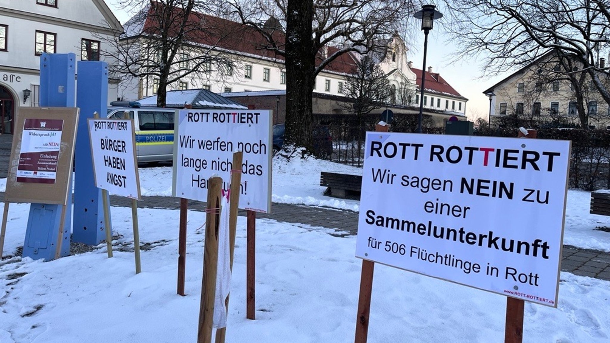 Zu sehen sind Protestschilder gegen eine Asyl-Unterkunft in Rott am Inn