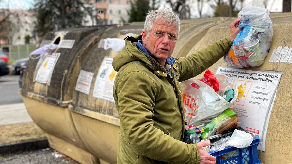 BR-Reporter Ulrich Hagmann entsorgt seinen Verpackungsmüll in einem Recyclingcontainer.