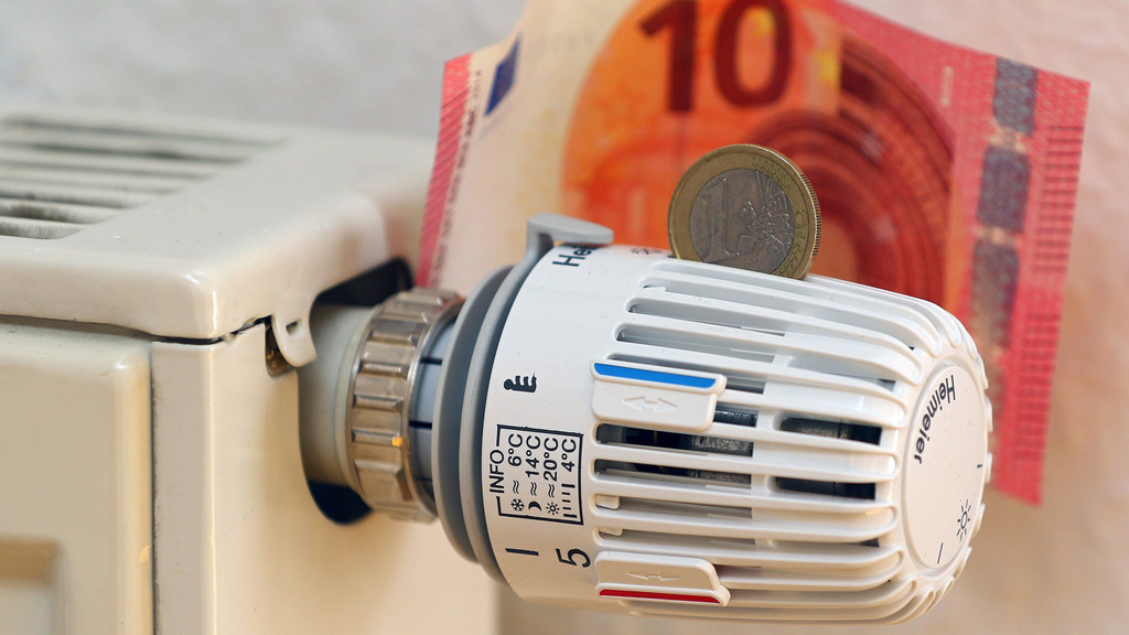Symbolbild zu Heizkosten: Ein Heizungsregler mit Euro-Münze vor Zehn-Euro-Schein