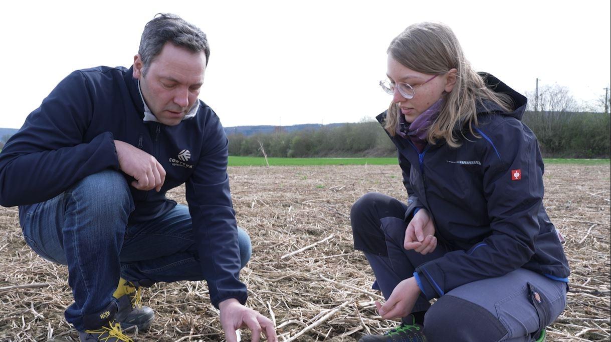 Landwirt Martin Goppelt und Franziska Sippl untersuchen einen Acker.