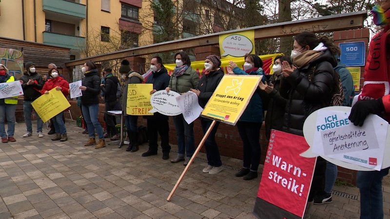 Menschen mit Protestschildern beim Warnstreik Verdi in Erlangen