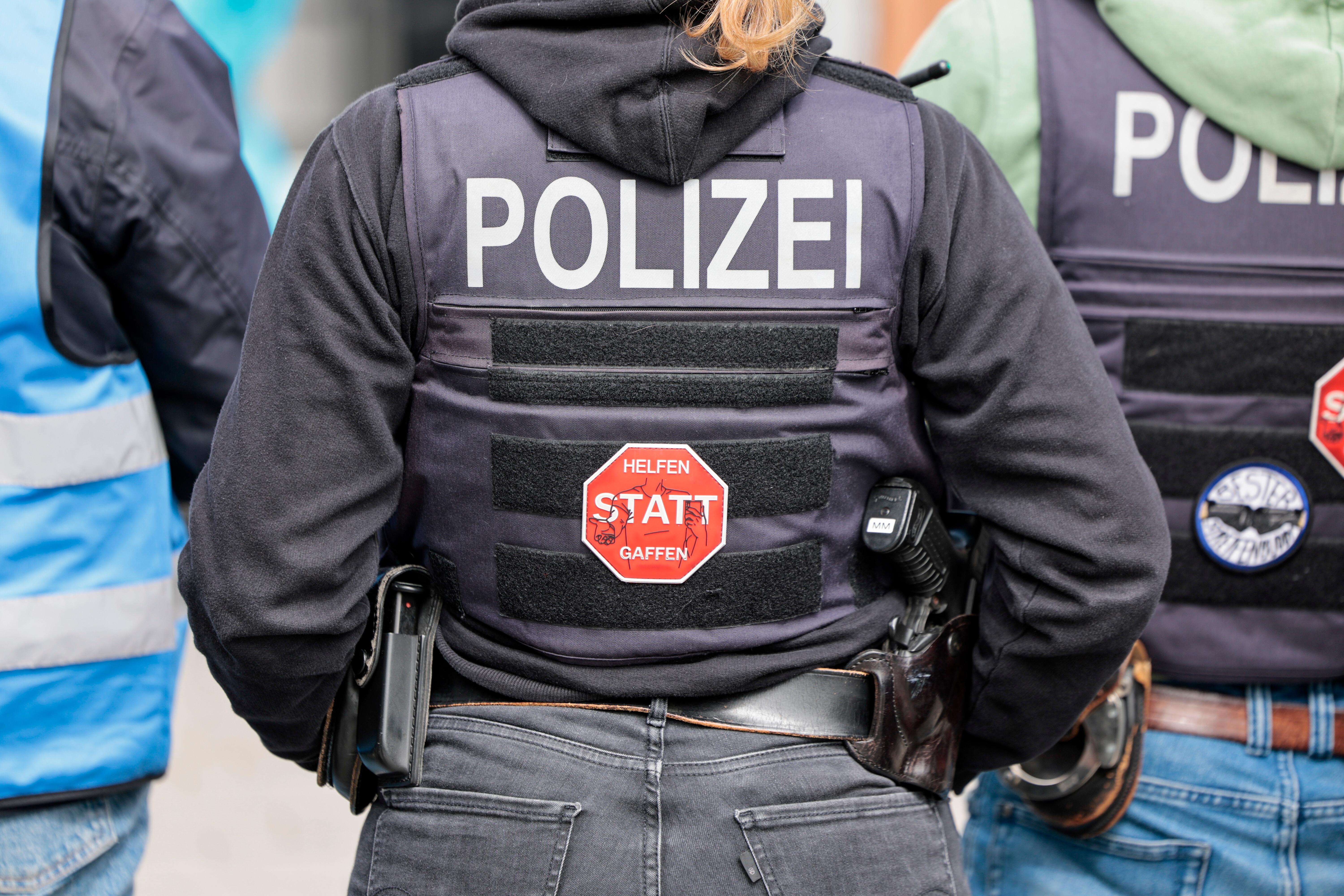 Eine Polizeibeamtin hat auf ihrer Schutzweste einen Aufkleber mit der Aufschrift: "Helfen statt Gaffen"