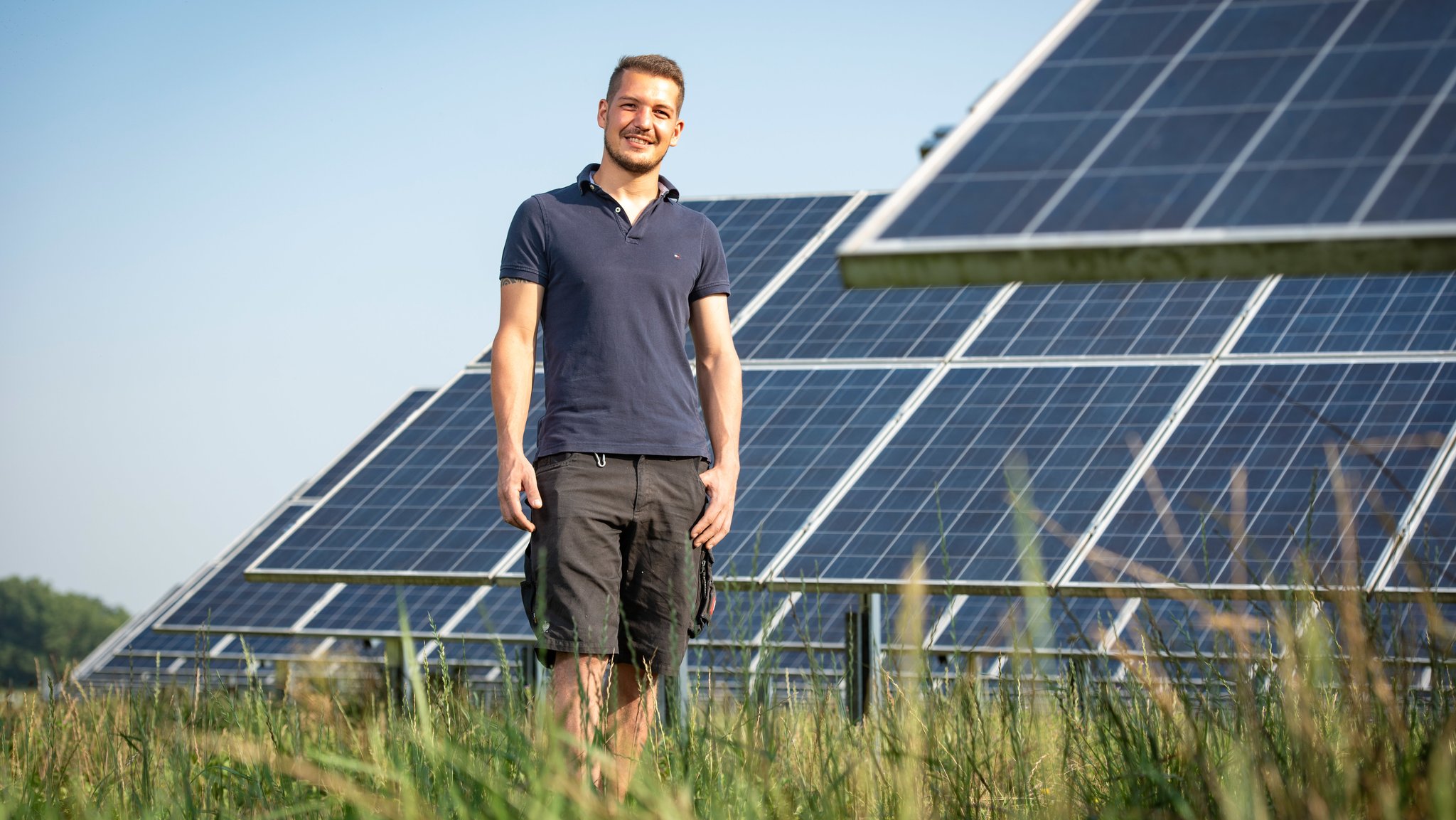 Alois Stefan Penninger auf einer Wiese vor Solaranlagen