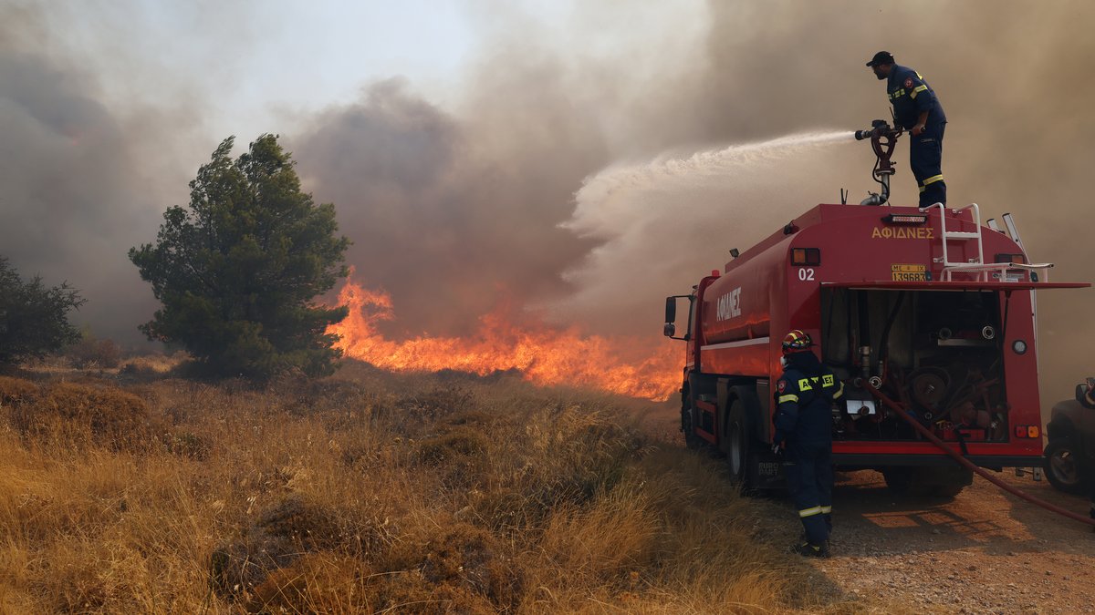 Feuerwehrleute versuchen ein Großfeuer nahe Athen zu löschen
