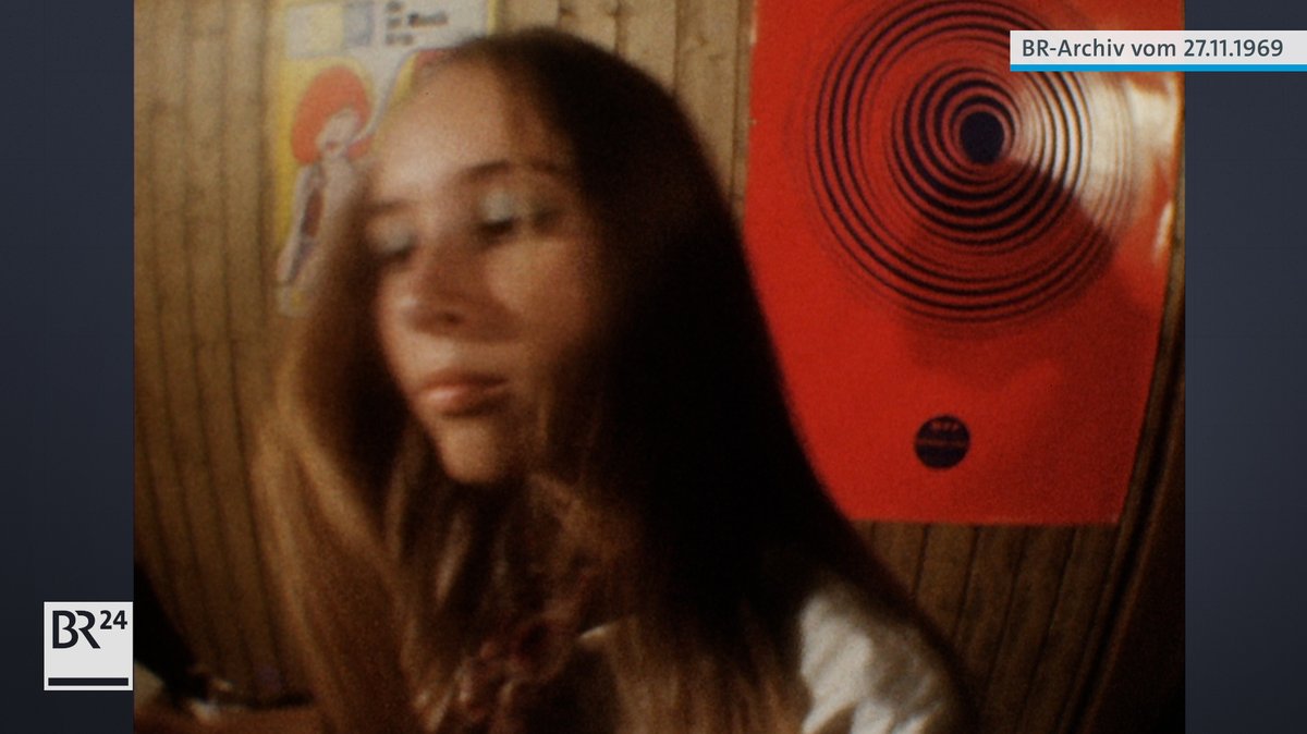 Frau beim Tanzen vor psychedelischem Poster
