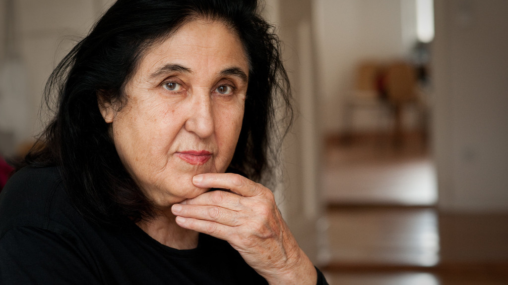 Die Autorin Emine Sevgi Özdamar blickt, die Hand am Kinn, nachdenklich in die Kamera