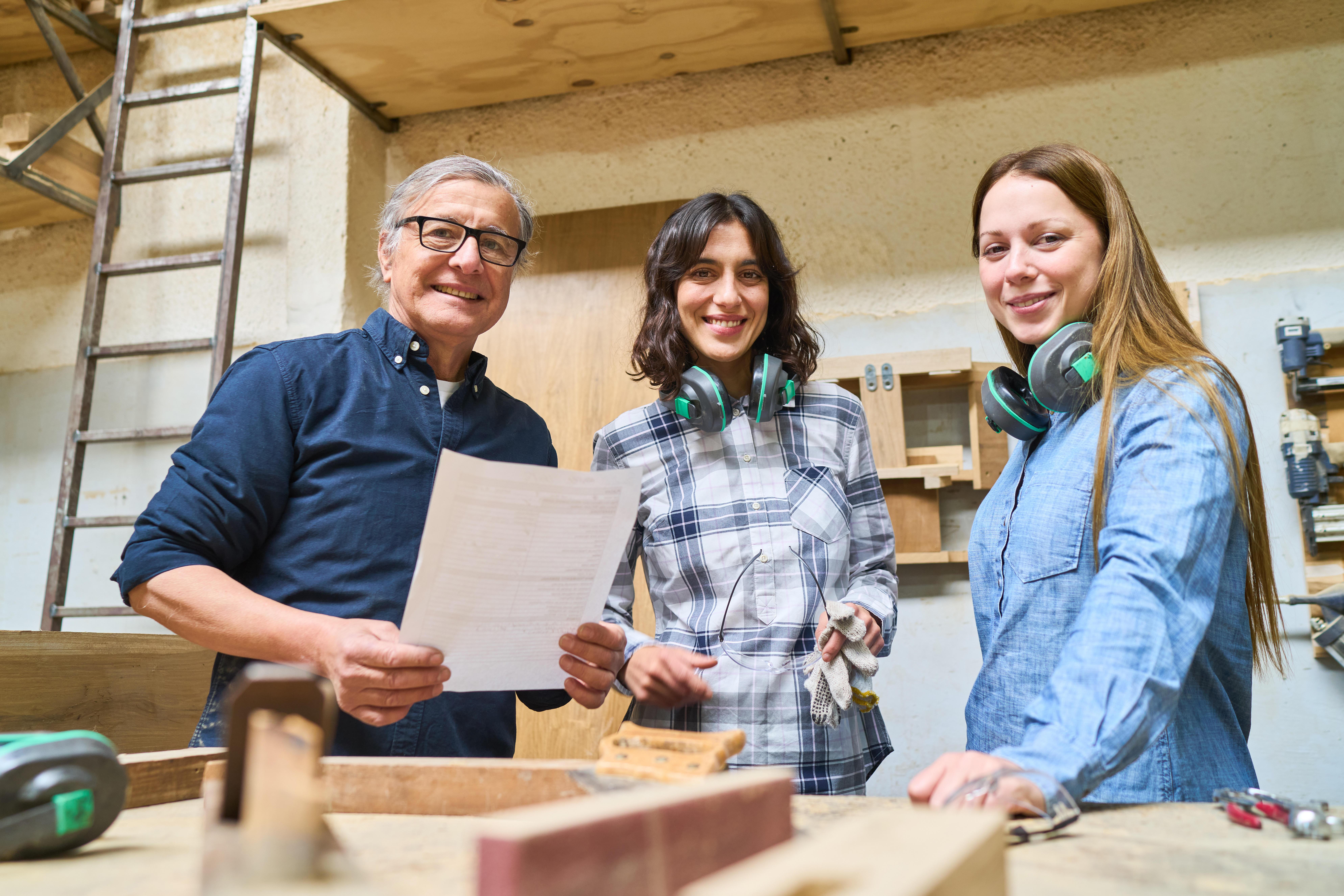 Teamarbeit in einer Holzfabrik: Junge Lehrlinge lernen Holzbearbeitung