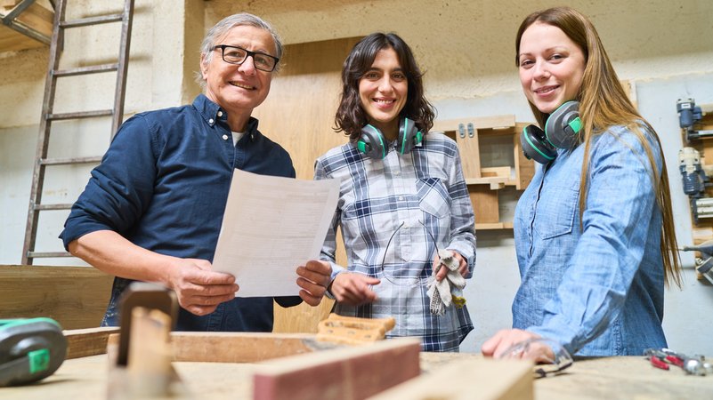 Teamarbeit in einer Holzfabrik: Junge Lehrlinge lernen Holzbearbeitung | Bild: picture alliance / Robert Kneschke Teamarbeit in einer Holzfabrik: Junge Lehrlinge lernen Holzbearbeitung