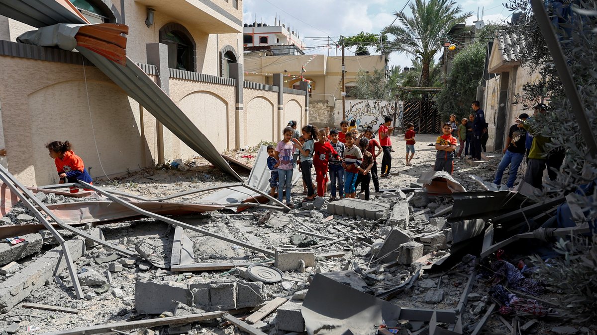 Kinder im Gazastreifen stehen vor einem von israelischen Raketen zerstörten Haus