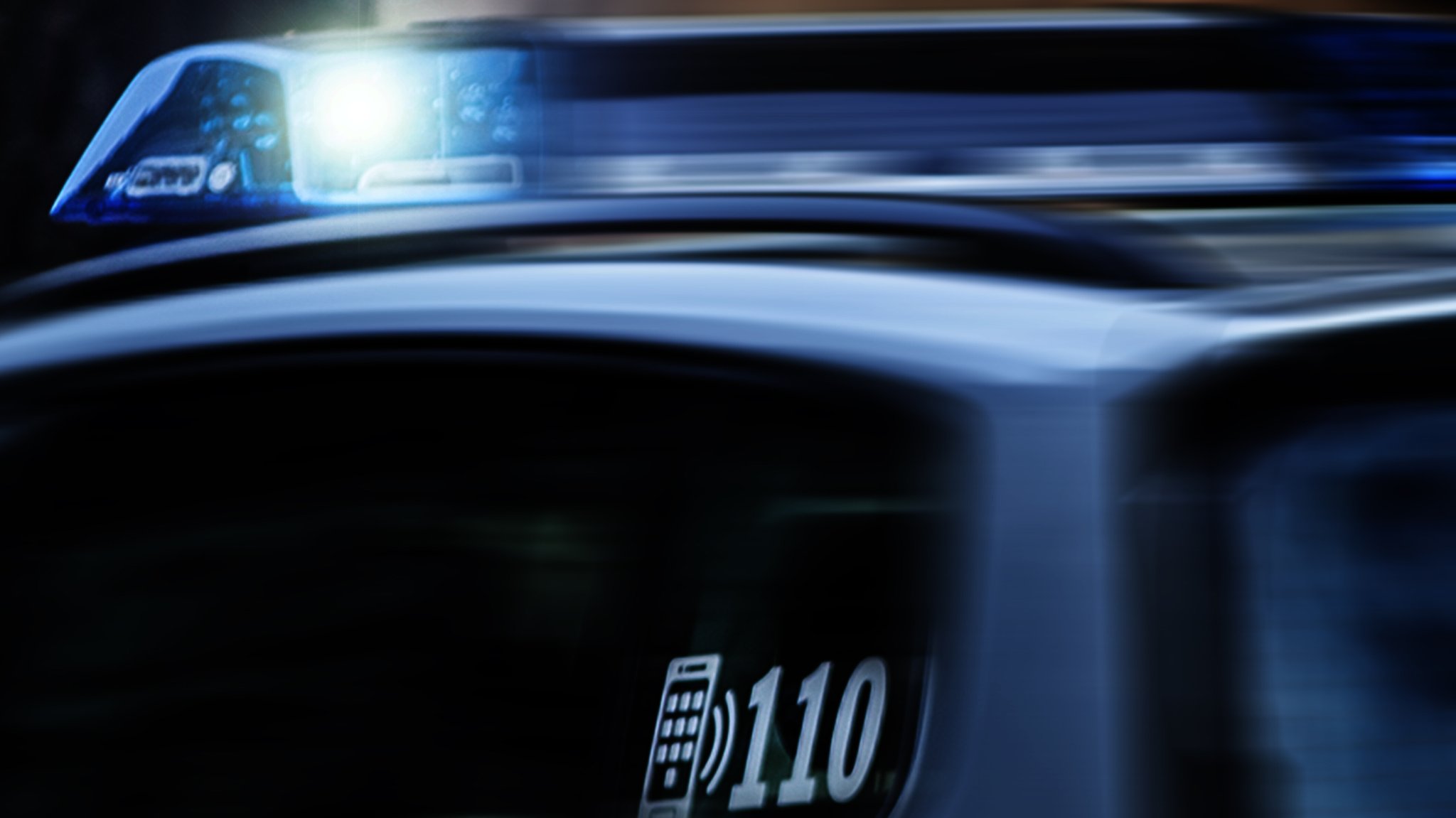 Symbolbild: Ein Einsatzfahrzeug der Polizei in Bayern nachts mit Blaulicht im Einsatz.