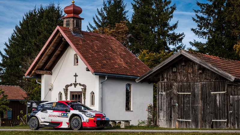 Das Auto von Titelgewinner Kalle Rovanperä - ein Toyota - steht vor einer ländlichen Kapelle.