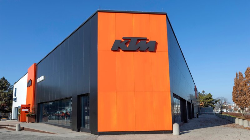 Ein Gebäude mit oranger Seitenwand, darauf der Schriftzug "KTM" | Bild: picture alliance / Weingartner-Foto / picturedesk.com | - Ein Gebäude mit oranger Seitenwand, darauf der Schriftzug "KTM"