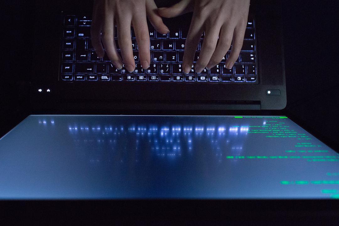 Hände auf einer schwarzen Laptop-Tastatur