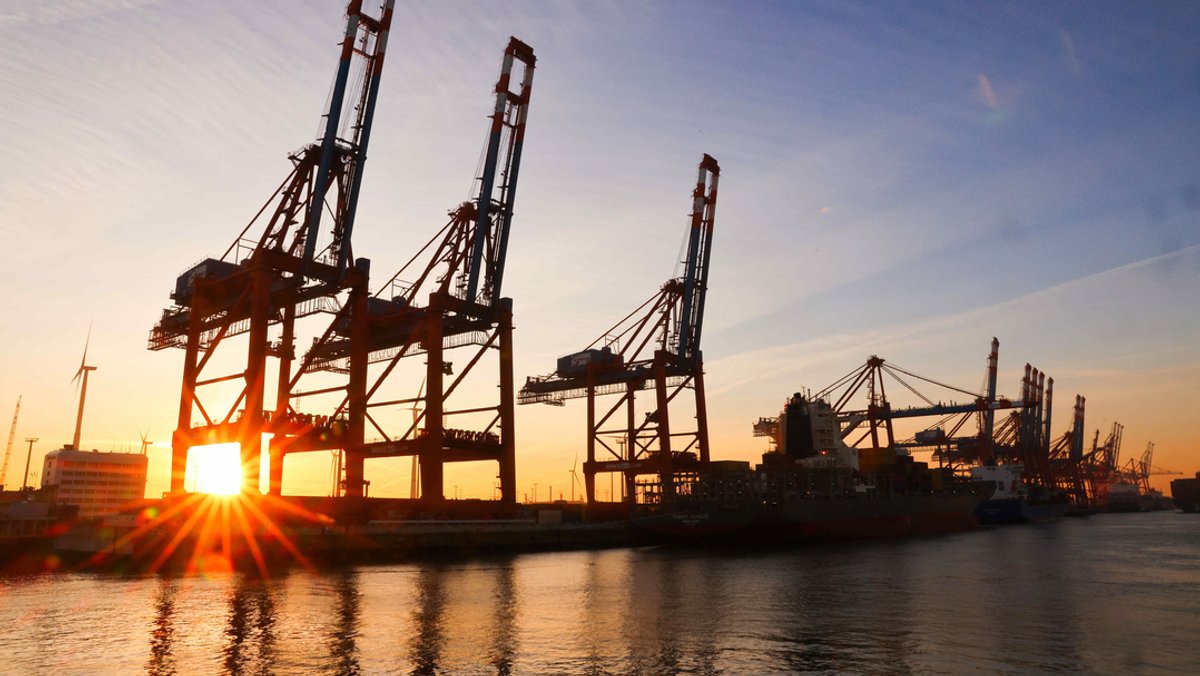Hamburg: Die Sonne geht hinter Containerbrücken auf dem Terminal Eurogate im Waltershofer Hafen unter.
