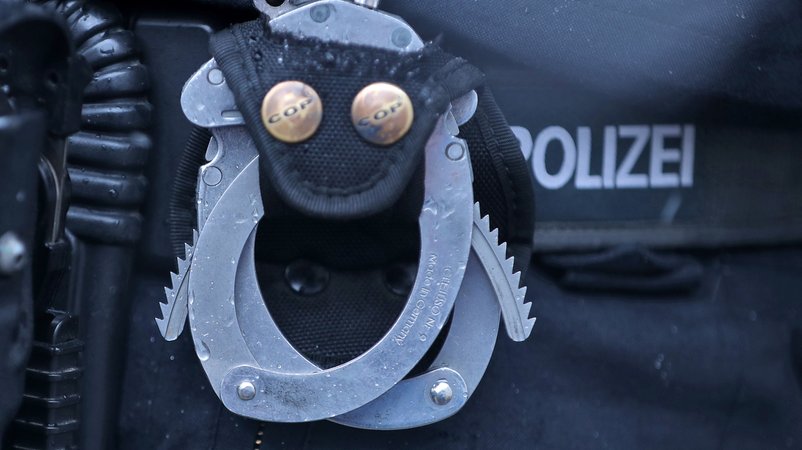 Handschellen am Gürtel eines Polizisten (Symbolbild)