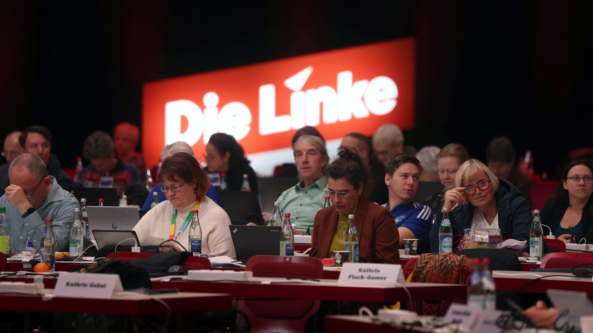 Delegierte sitzen vor dem Logo der Partei. Vom 17.11 bis 19.11. findet in Augsburg der Bundesparteitag der Partei statt.