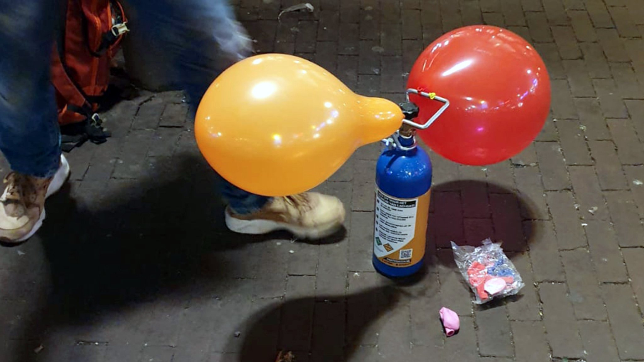 Eine Person konsumiert Lachgas über einen Luftballon