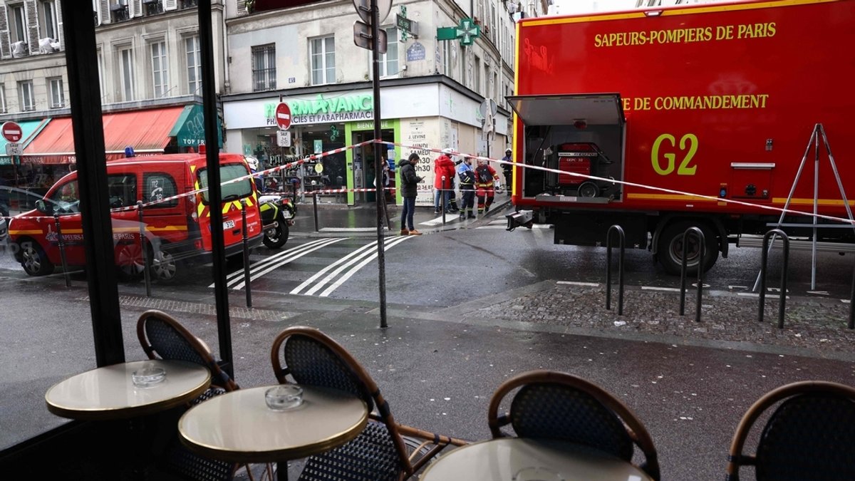 Die Sicht aus einem Pariser Café auf die Straße, wo die Fahrzeuge der Rettungskräfte parken.