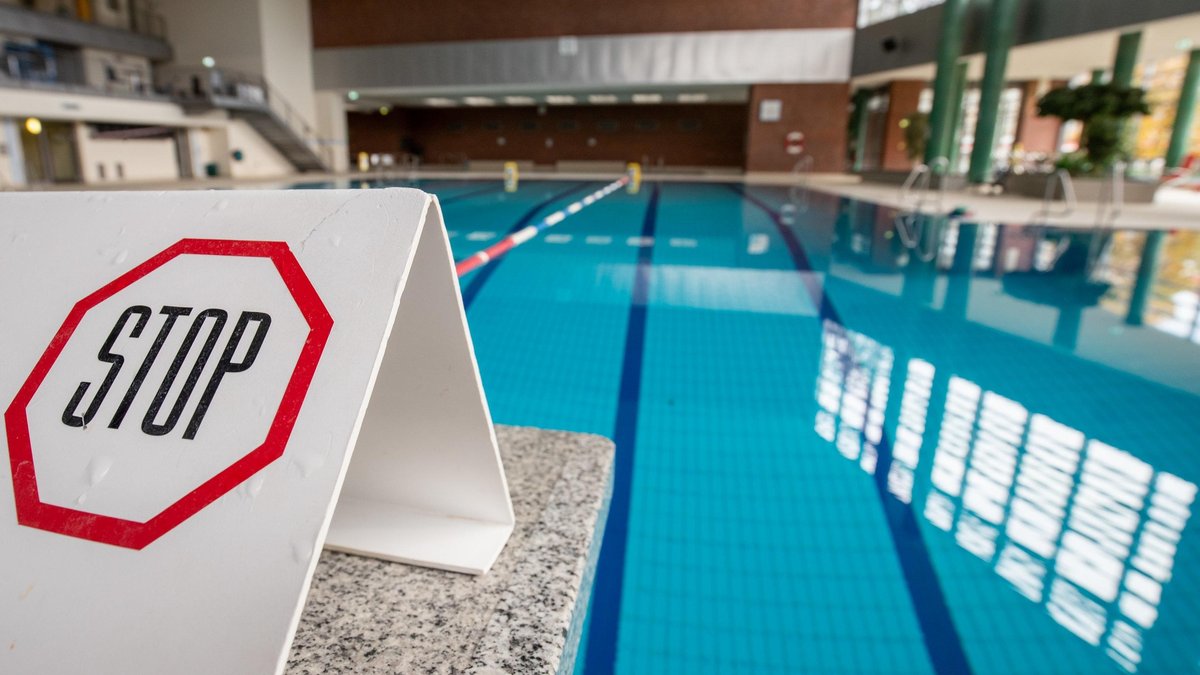 Stop" steht auf einem Schild auf einem gesperrten Startblock am Beckenrand eines Schwimnbades. In ganz Deutschland hat ein vierwöchiger Teil-Lockdown begonnen, um die Ausbreitung des Coronavirus zu bremsen. 