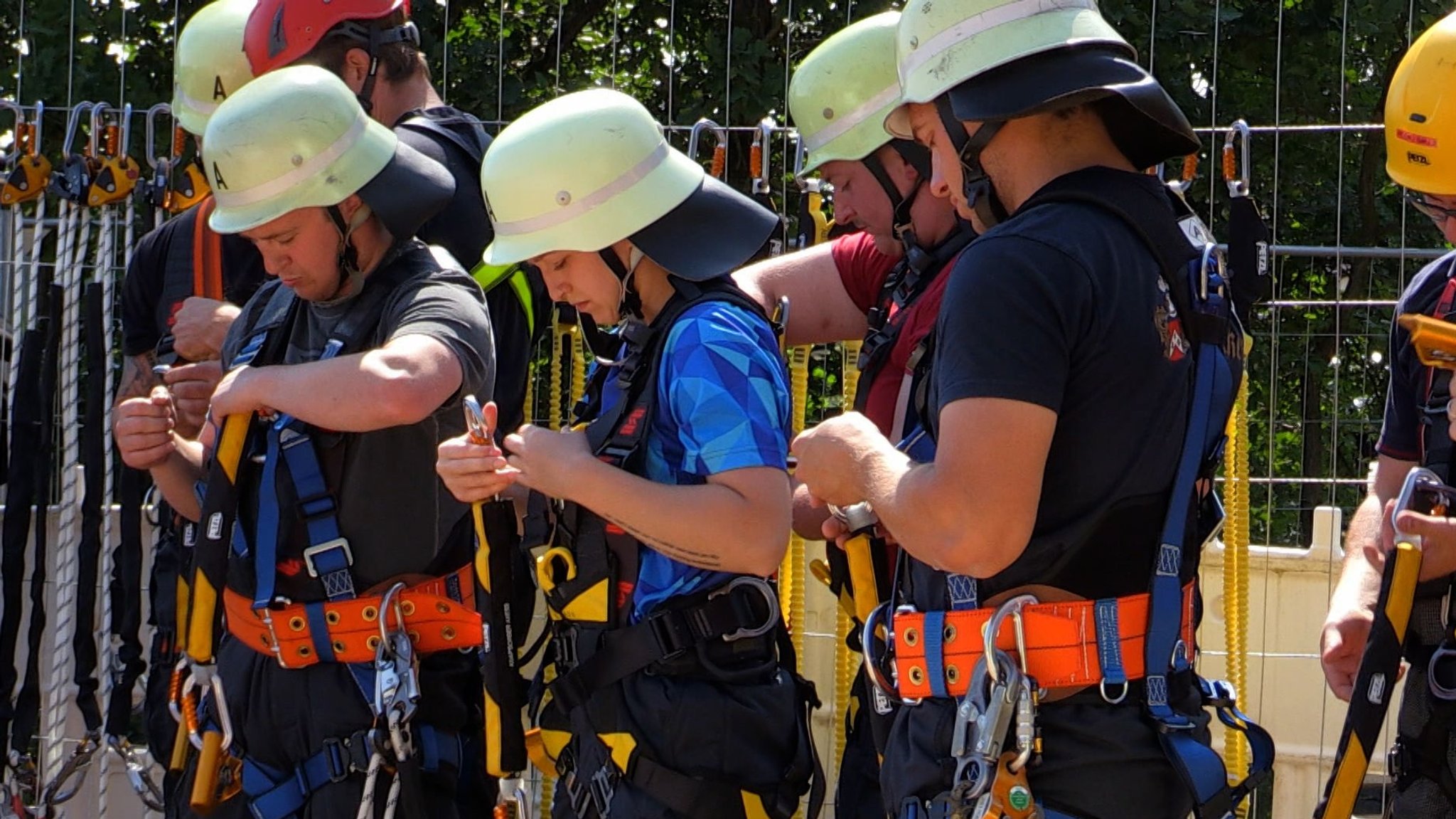 Die Feuerwehrkräfte beim Anlegen des Gurtzeugs