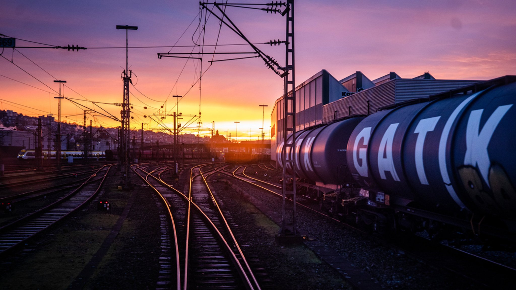 Kohlezug von Heilbronn nach Plochingen - im Hintergrund geht die Sonne über dem Bahnhof von Plochingen auf. 