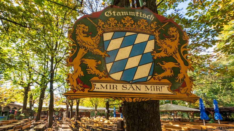 (Symbolbild) Ein Stammtisch-Schild mit der Aufschrift "Mir san mir" hängt im Biergarten des Hofbräu-Kellers in München. | Bild: pa/dpa/Peter Kneffel (Symbolbild) Ein Stammtisch-Schild mit der Aufschrift "Mir san mir" hängt im Biergarten des Hofbräu-Kellers in München.