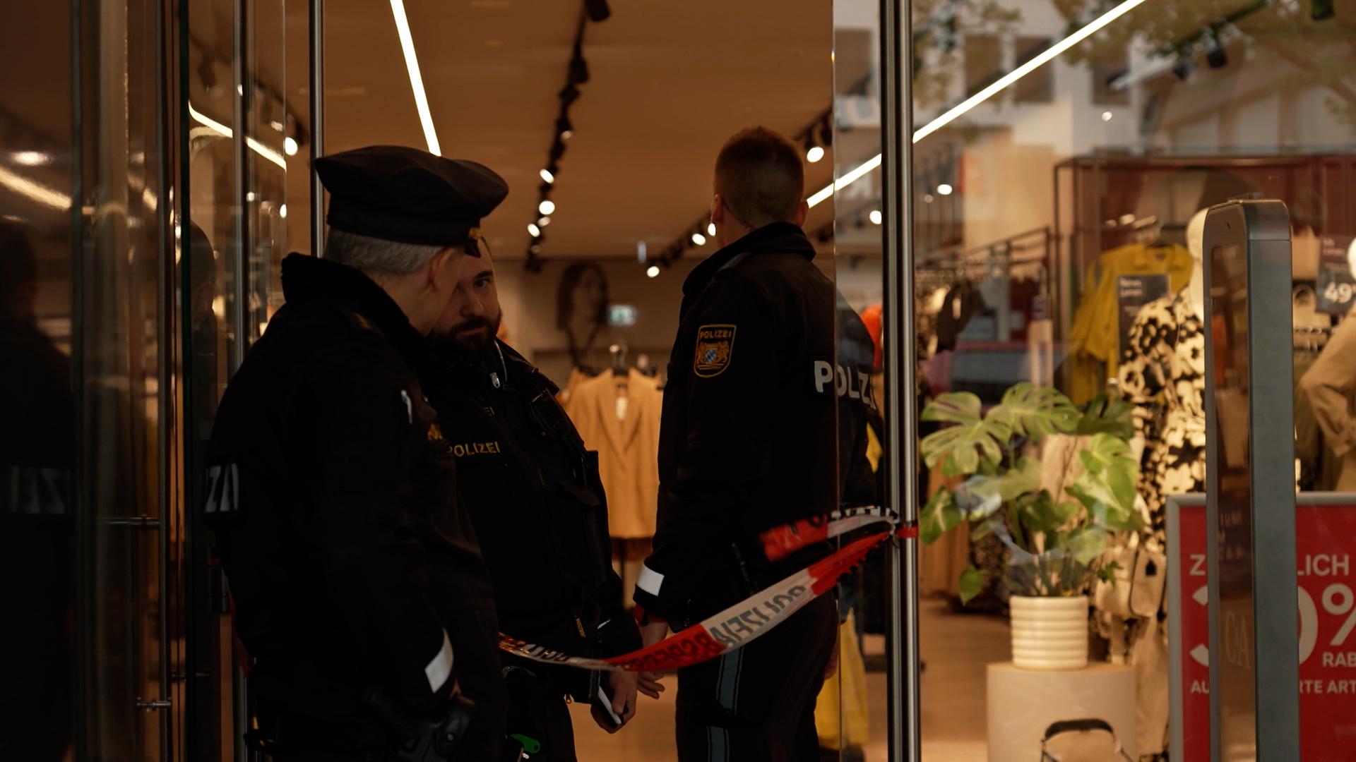 Polizisten am Eingang eines Kaufhauses, in dem es gebrannt hat