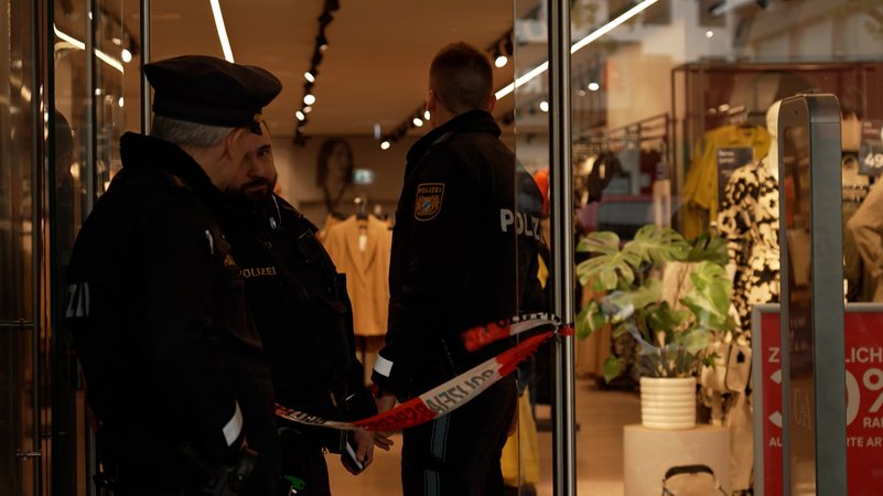 Polizisten am Eingang eines Kaufhauses, in dem es gebrannt hat