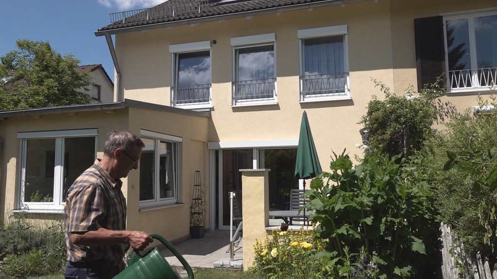 Immobilienbesitzer Wolfgang Heindl gießt die Blumen vor seinem Haus. 