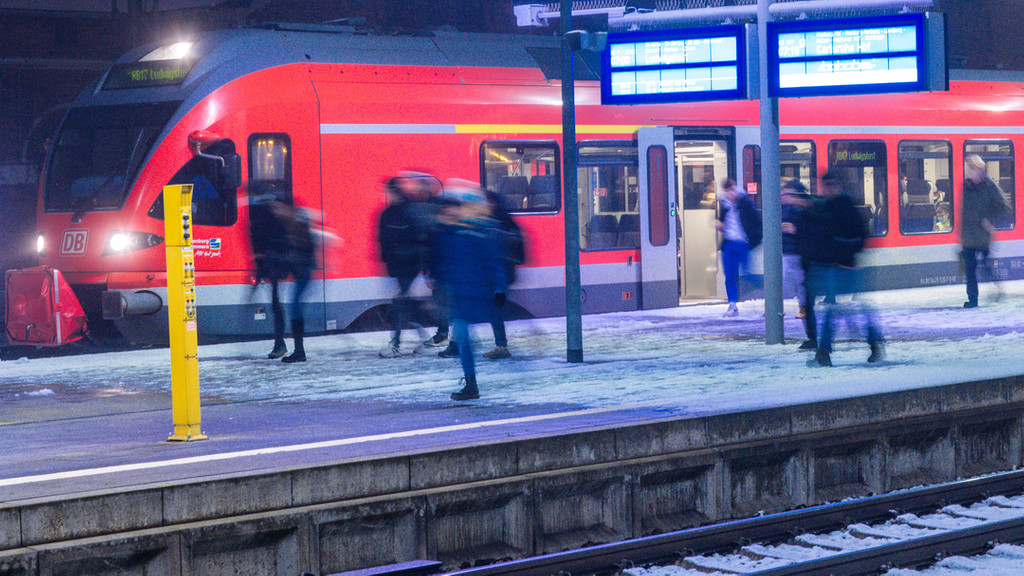 Fahrgäste steigen auf dem Bahnhof aus einem Regionalzug.