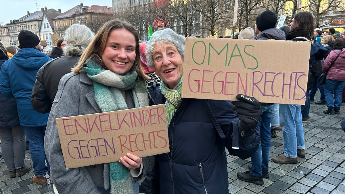 Zwei Frauen halten Plakate in Händen, auf den steht zu lesen: "Enkelkinder gegen Rechts" und "Omas gegen Rechts" . 