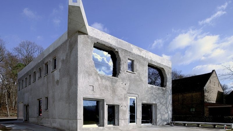 Ein Bunkerartiger Quaderbau aus grobem Beton, darin unterschiedlich große Fenster und Türen: Die "Antivilla" in Potsdam am Krampnitzsee | Bild: Thomas Spier Ein Bunkerartiger Quaderbau aus grobem Beton, darin unterschiedlich große Fenster und Türen: Die "Antivilla" in Potsdam am Krampnitzsee