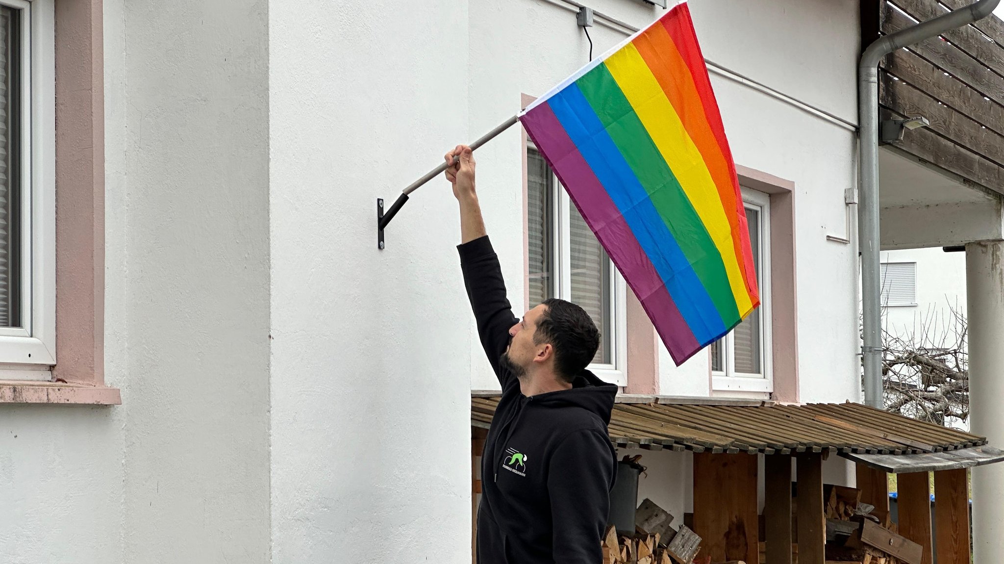 Manuel Heilmann mit der Regenbogenflagge an seinem Haus | Bild: Manuel Heilmann Manuel Heilmann mit der Regenbogenflagge an seinem Haus