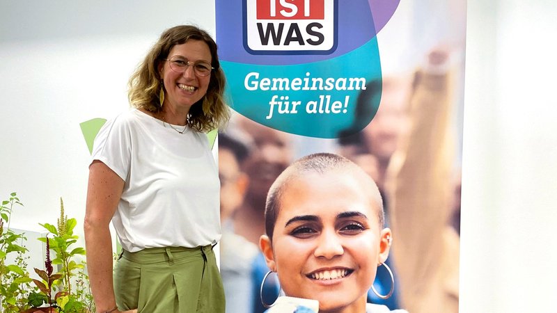 Autorin Andrea Weller-Essers steht vor einem Plakat für ihr neues Buch. | Bild: Tessloff Verlag Autorin Andrea Weller-Essers steht vor einem Plakat für ihr neues Buch.
