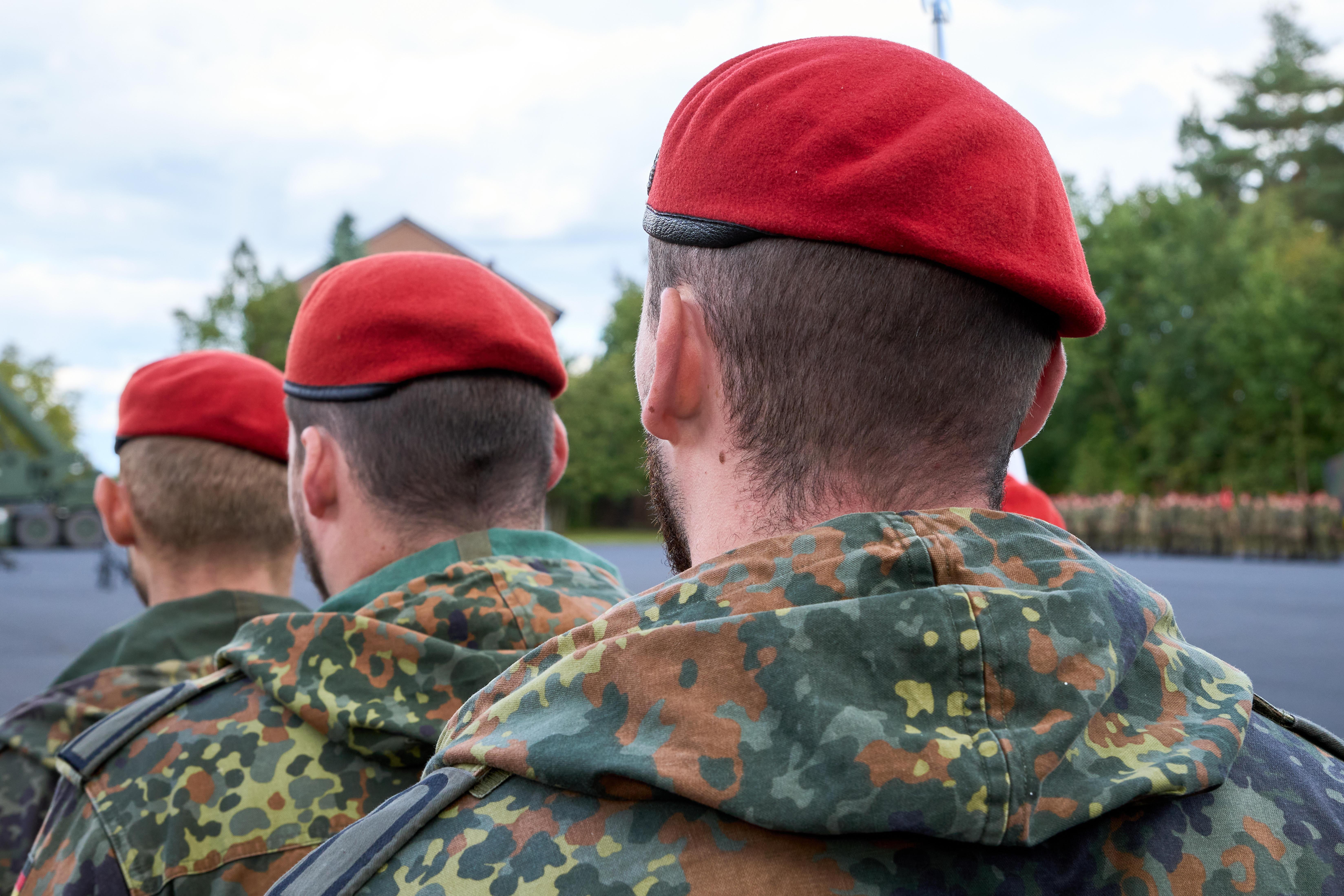 Von hinten aufgenommene Soldaten der Deutschen Bundeswehr in Flecktarn-Uniform und roten Baretten. | Bild:picture alliance / CHROMORANGE | Michael Bihlmayer
