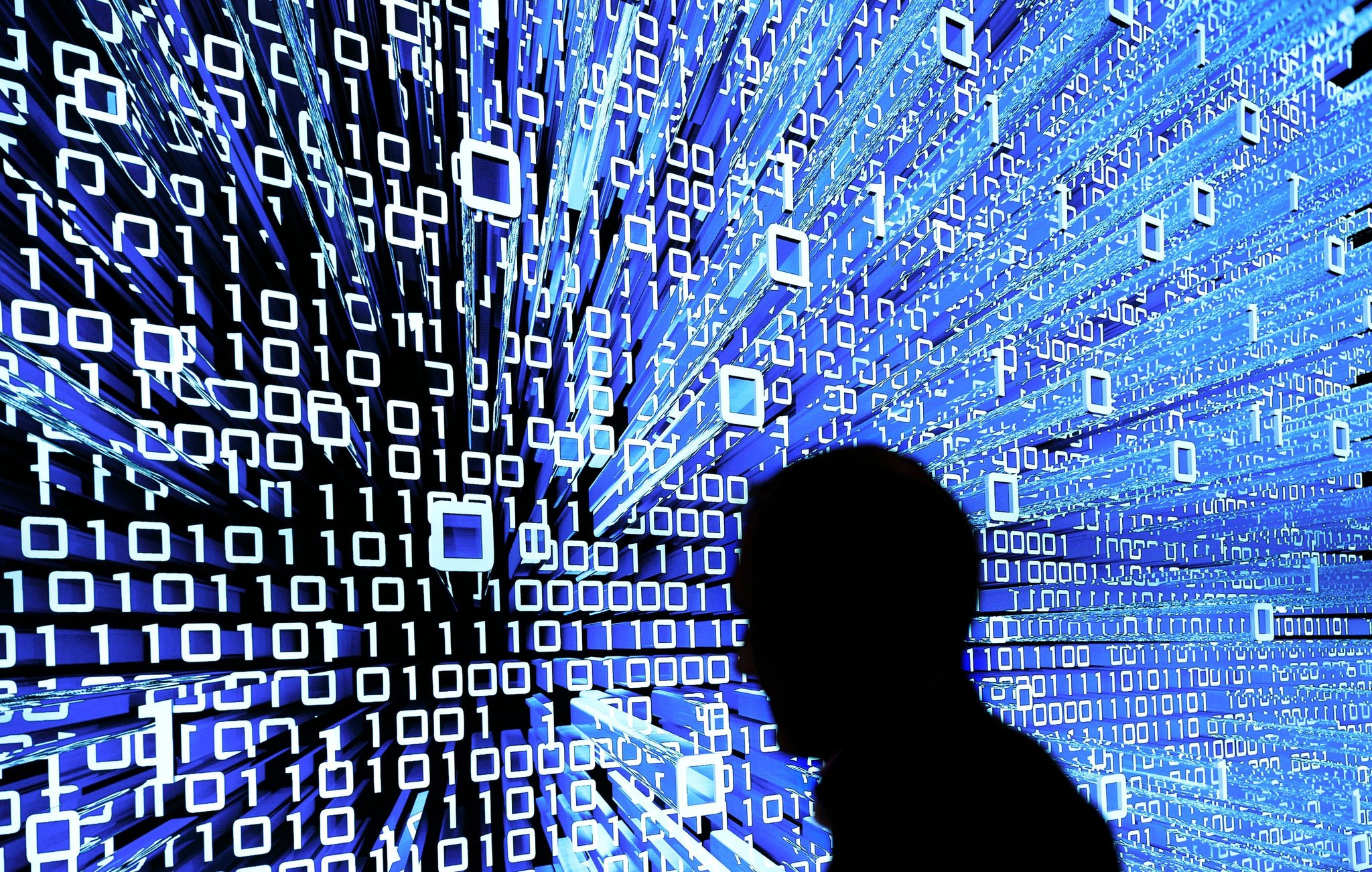 ARCHIV - 16.03.2015, Niedersachsen, Hannover: Ein Messebesucher geht an einem Leuchtdisplay auf der Messe Cebit vorbei. (zu dpa: «Mehring warnt: KI braucht klare Leitplanken») Foto: Peter Steffen/dpa +++ dpa-Bildfunk +++